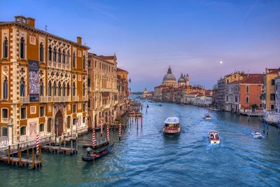 Nice view of grand canal in venice, people visiting around in a water taxi.