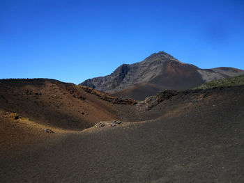 Scenic view of desert against clear blue sky