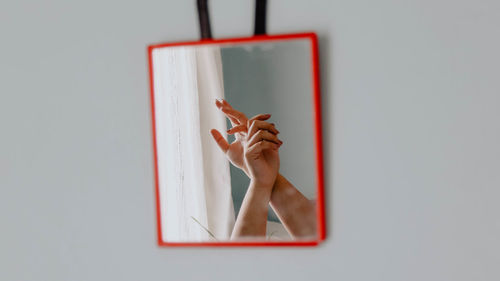 Cropped image of woman hands reflecting in mirror