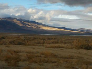 Scenic view of mountains against cloudy sky