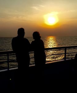 Silhouette of man in sea at sunset