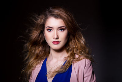 Portrait of a beautiful young woman over black background