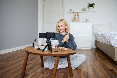 Young woman using mobile phone while sitting at home