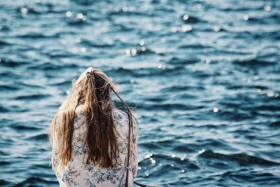 Rear view of woman standing in sea