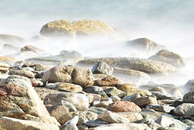 Scenic view of rocks in sea against sky