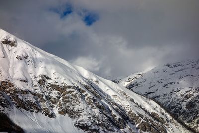 Scenic view of snowcapped mountains against cloudy sky