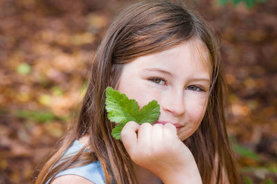 Portrait of girl holding leaves