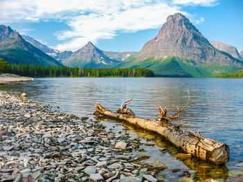 Scenic view of lake by mountains against sky