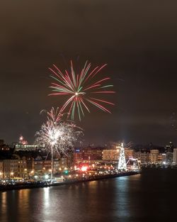 Firework display over river at night
