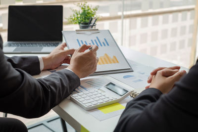 Midsection of businessman having discussion with colleague