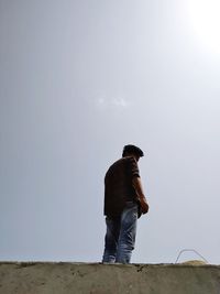 Low angle view of man standing wall against sky