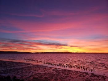 Scenic view of sea against dramatic sky during sunset