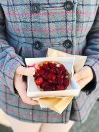 Close-up of woman holding strawberries in plate