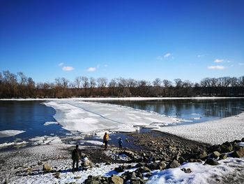 Scenic view of frozen lake against blue sky