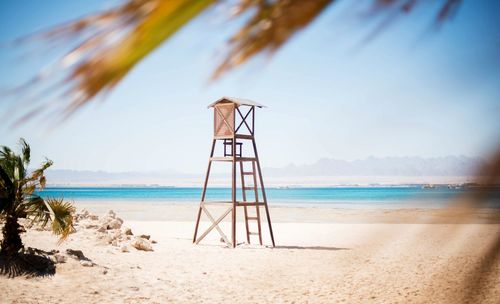 Lifeguard hut on beach against sky