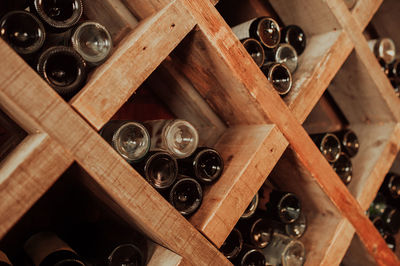 Dark wooden storage cabinet for bottle with plenty of empty bottled glass