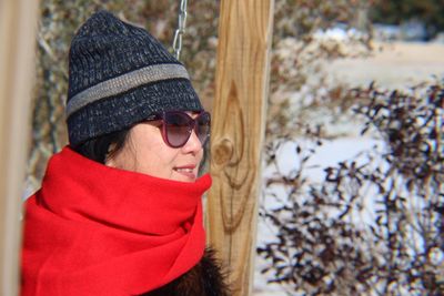 Close-up of smiling woman in sunglasses and warm clothes
