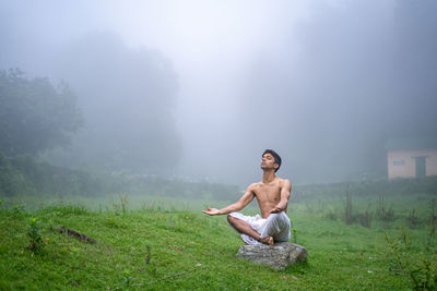 A man practicing meditation and zen energy yoga in mountains.