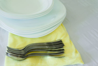 High angle view of plates with forks and spoon on table