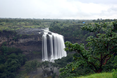 Scenic view of waterfall against sky