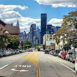 View of city street against cloudy sky