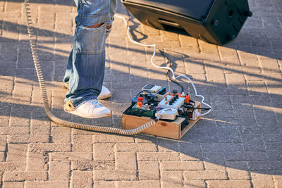 Guitar pedalboard effects pedal box for electric guitar on floor at outdoor rock party