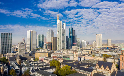 Modern buildings in city against cloudy sky