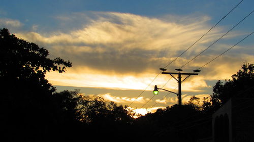 Silhouette of trees against cloudy sky