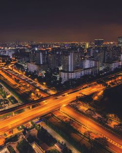 High angle view of city lit up at night