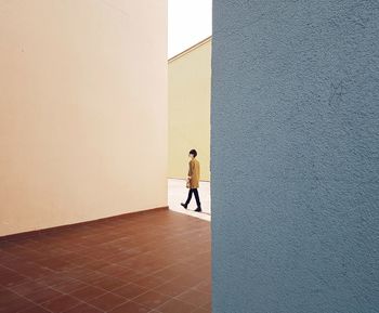 Rear view of man standing against wall