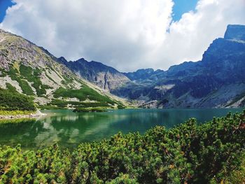 Scenic view of lake by mountains against sky