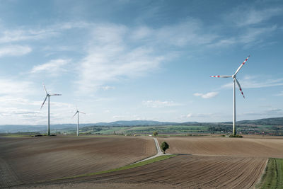 Windmill on field against sky