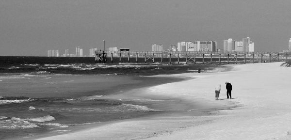 Man on beach against sky in city