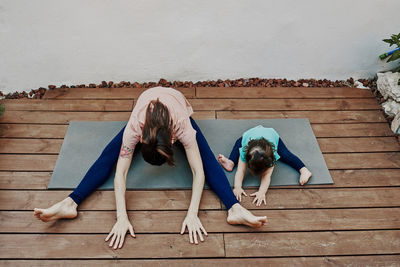 Mother and daughter doing yoga in the house