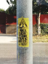 Information sign on pole against plants