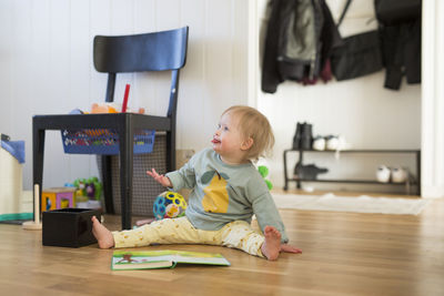 Cute boy playing with toy on floor at home