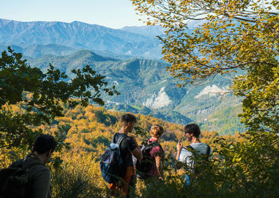 People standing by tree mountain