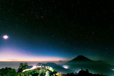 Scenic view of silhouette mountains against sky at night