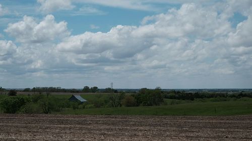 Scenic view of field against cloudy sky