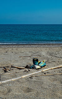 Deck chairs on beach against clear blue sky