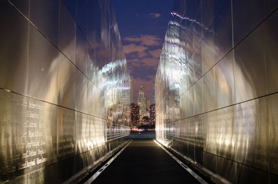 Illuminated street amidst buildings at night