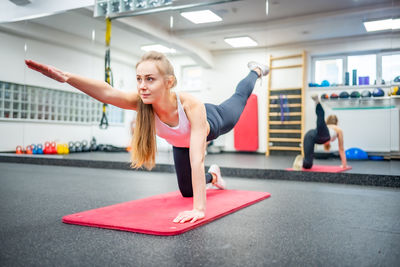 Side view of woman exercising in gym