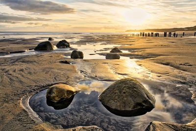 Scenic view of beach against sky during sunset