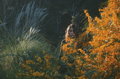 Woman standing amidst plants on field