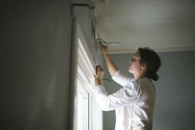 Woman painting wall at home