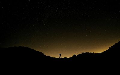 Low angle view of silhouette mountain against sky at night