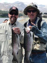 Portrait of smiling friends holding fishes