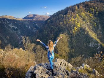 Rear view of woman standing on mountain