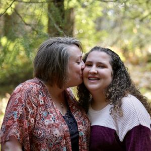 Close-up of mother kissing daughter while standing outdoors
