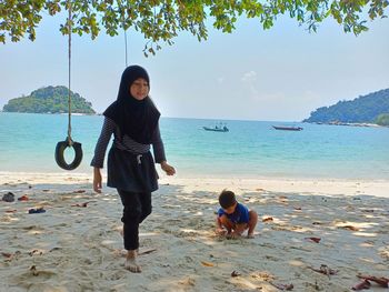 Full length of woman on beach against sky